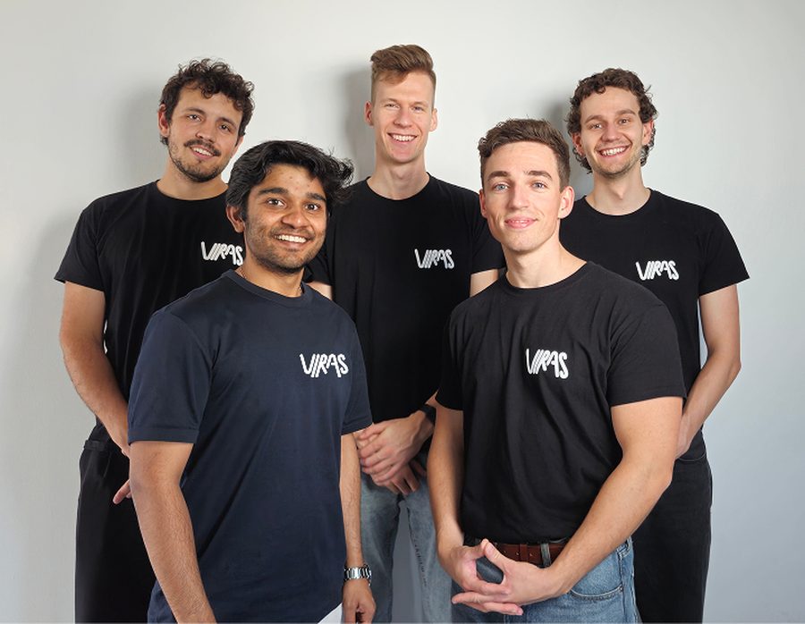 The five-person VIRAS Solutions team in matching black VIRAS t-shirts, smiling against a plain wall, with Abhiram in front on the left